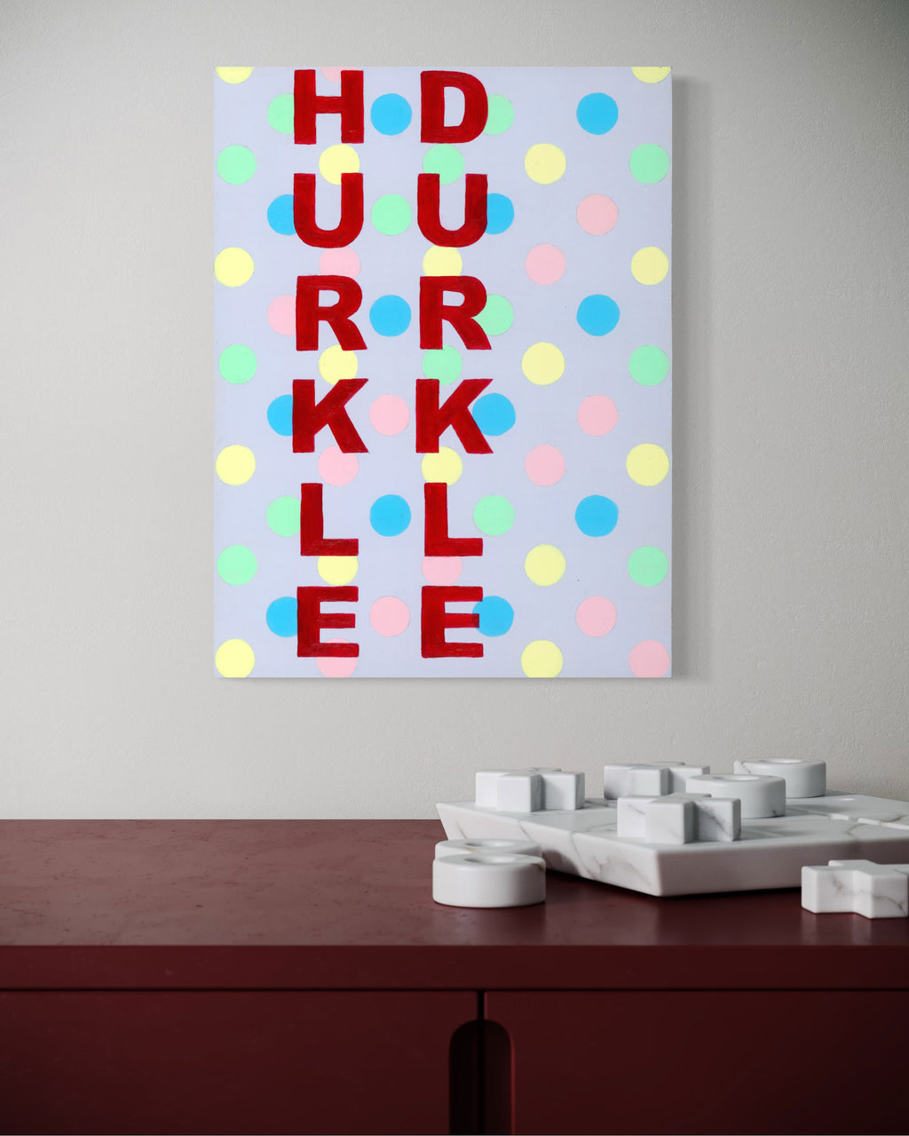 Bold red letters dance on a pastel polka dot background, creating a lively tapestry of text and colour.