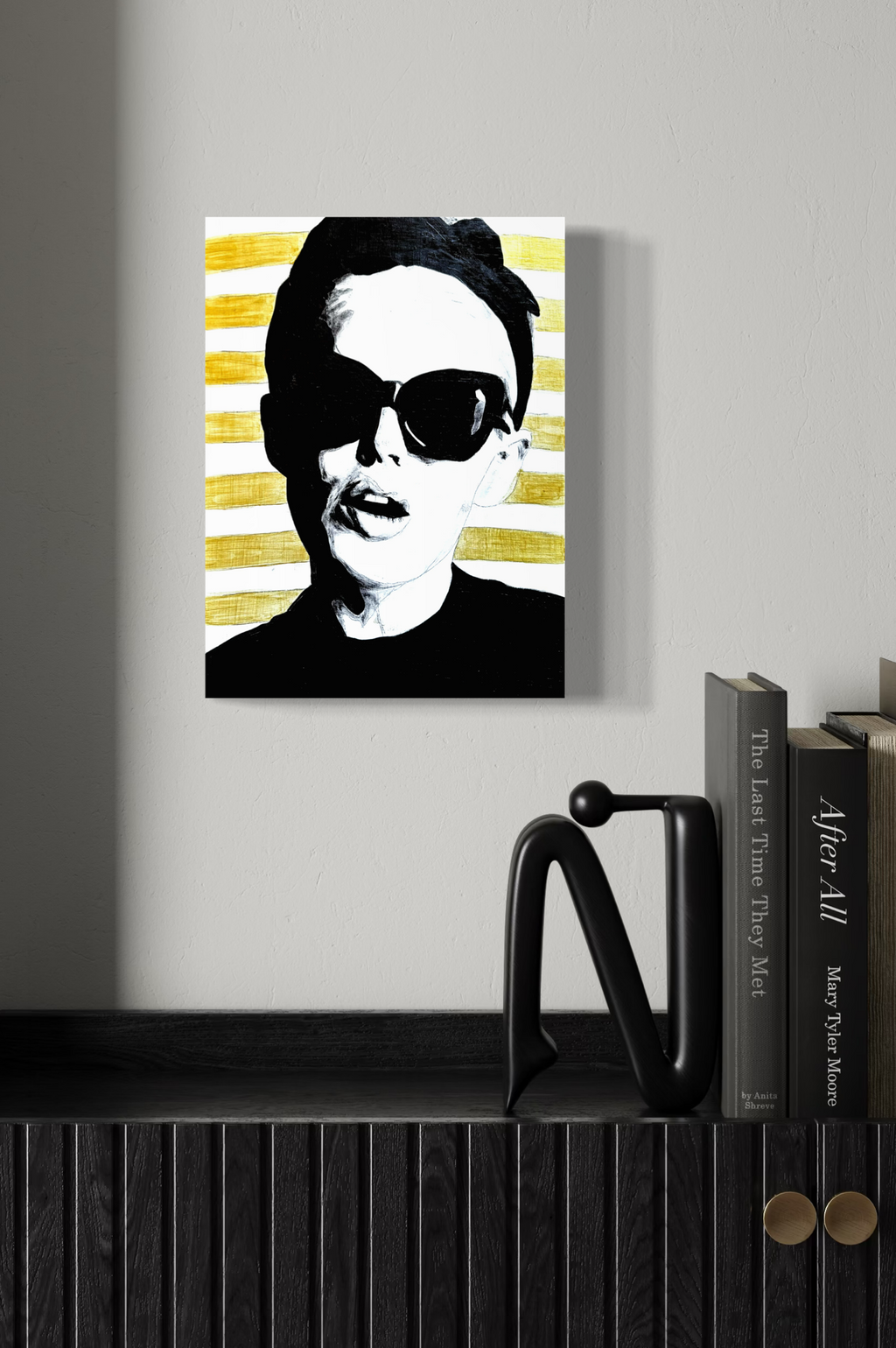 Original painting on board of a stylised woman wearing sunglasses, with gold stripes, on a wall above a bookshelf.