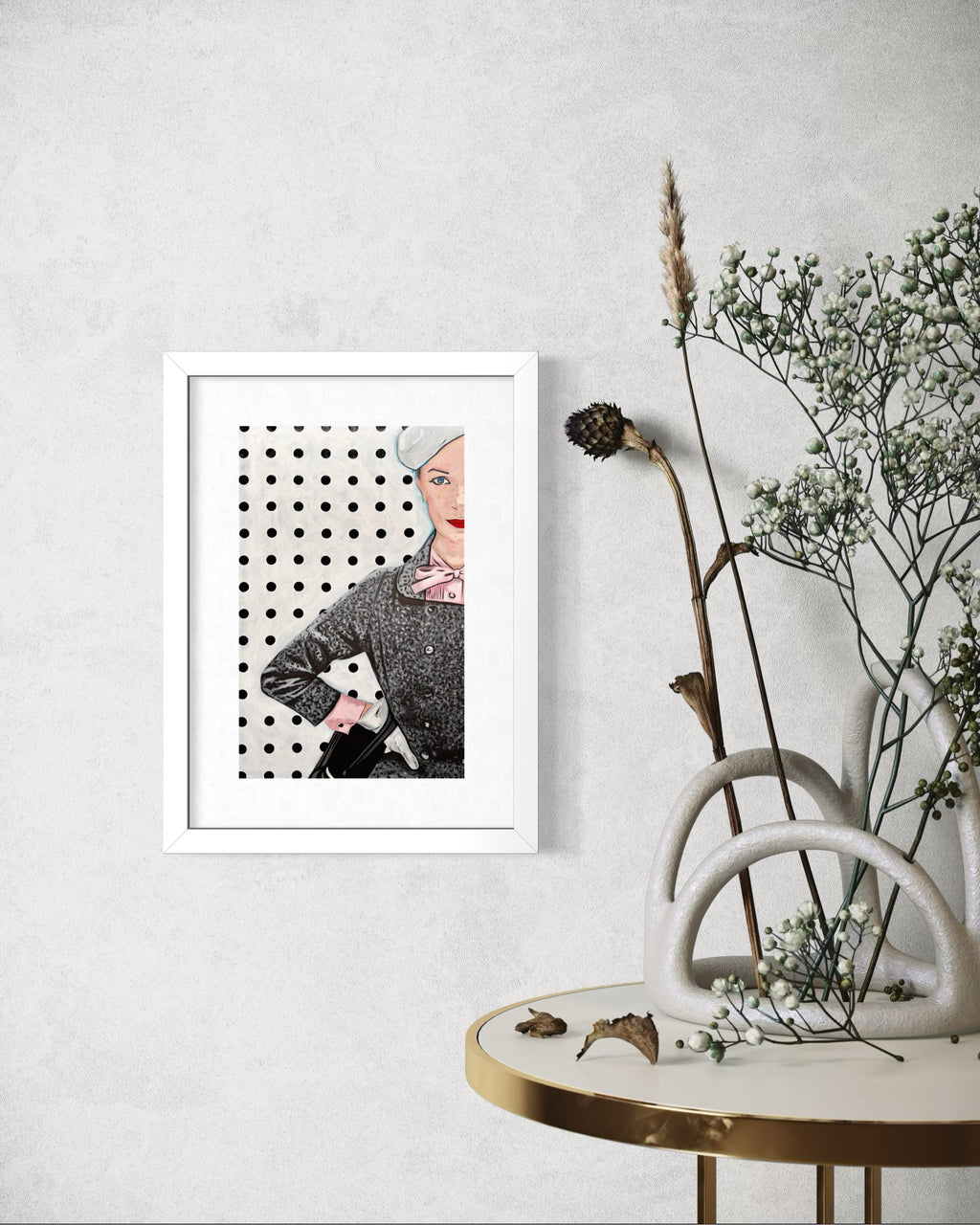 Framed limited edition print of a stylised portrait on a wall with a decorative table and plants.