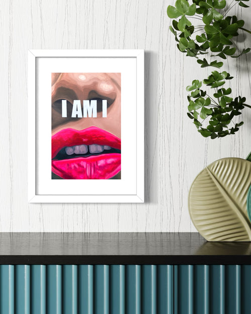 Framed artwork of a limited edition print with a close-up of lips and the text 'I AM I' on a wall with decorative elements.