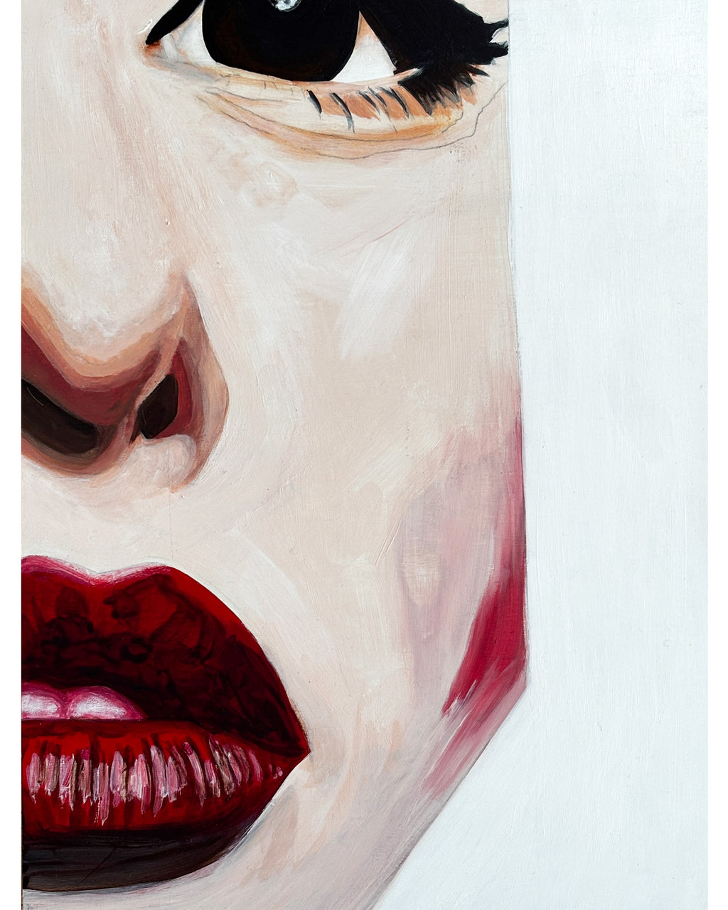 An art print featuring a close-up portrait of a woman's face with bold red lips.