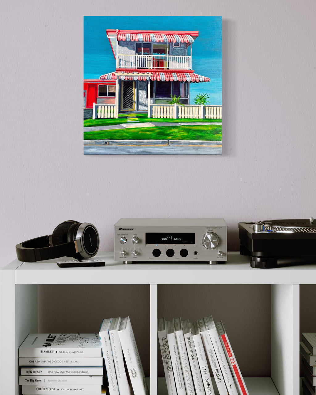 'The Classic' by Annie Pritchard displayed above a white shelf with a stereo, turntable and books
