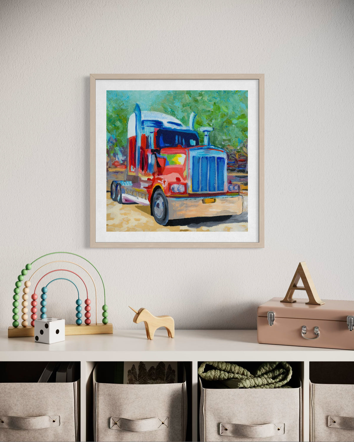 A framed colorful painting of a semi-truck hanging on a light gray wall above a shelf with toys and storage bins.